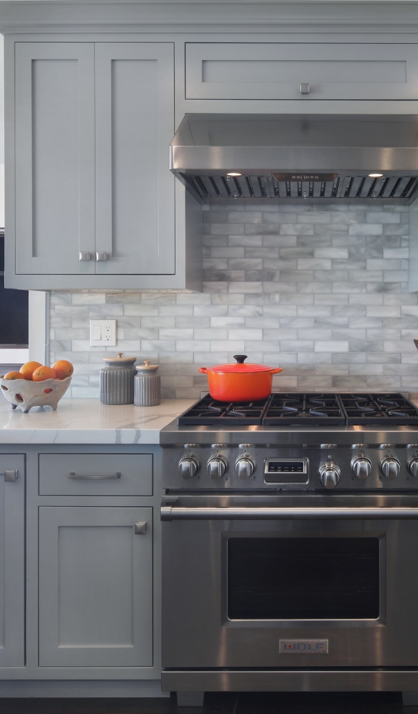 Большая газовая плита в серой кухне 