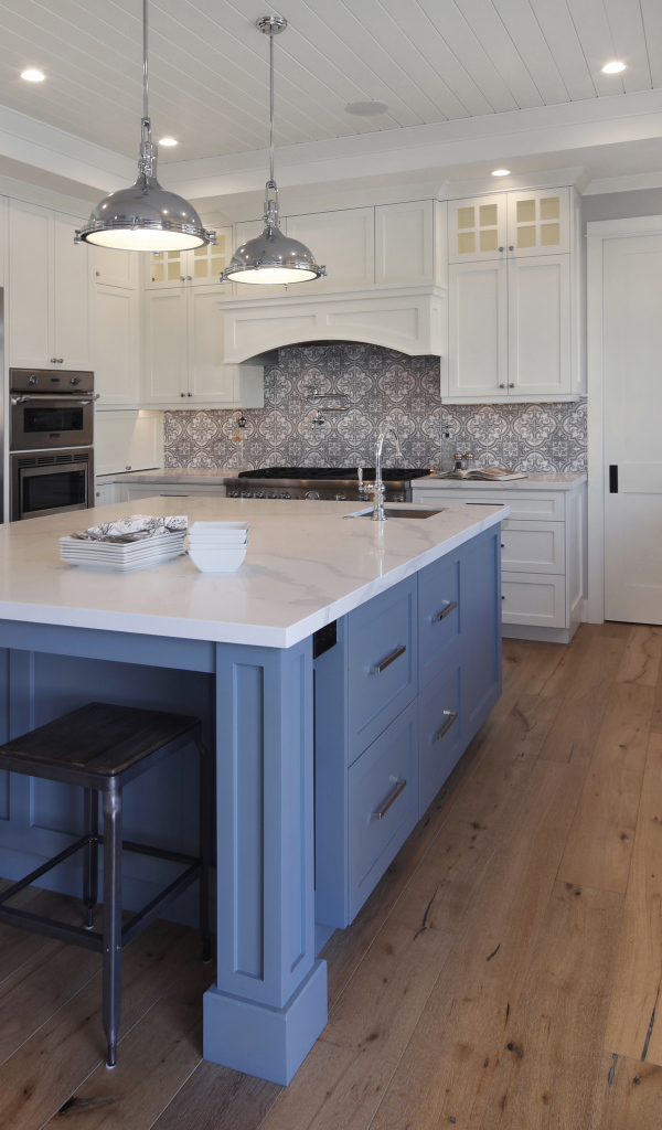 Большой серый стол в просторной белой кухне 