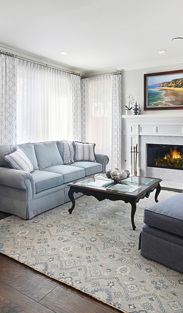 Большая гостиная комната с камином и живыми цветами