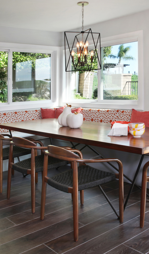 Большой деревянный стол и диван у окна в гостиной 