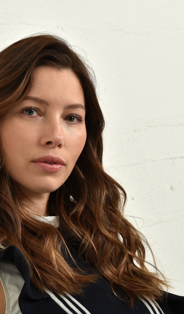 Грустная актриса Джессика Бил сидит у стены