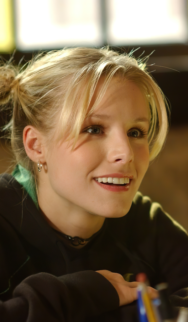 Улыбающаяся актриса Кристен Белл сидит в классе 