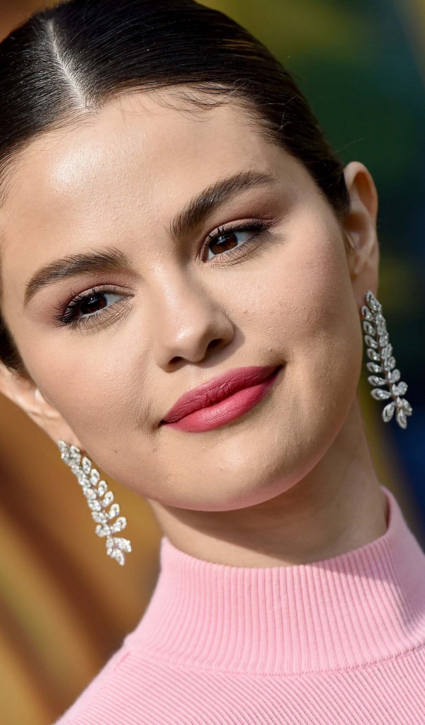 Улыбающаяся актриса и певица Селена Гомез с сережками в ушах