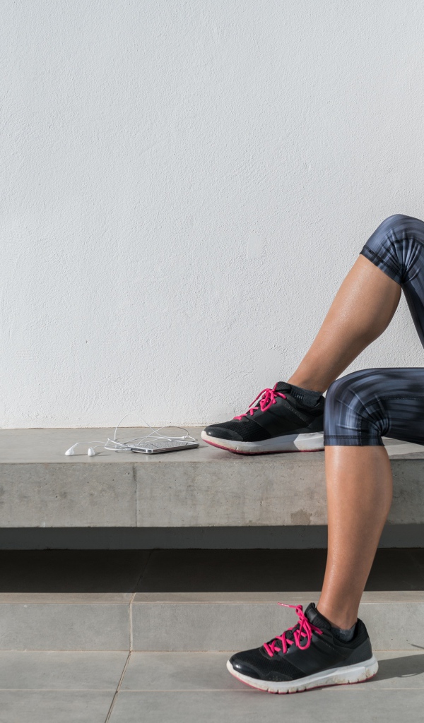 Спортивная девушка в костюме отдыхает после тренировки