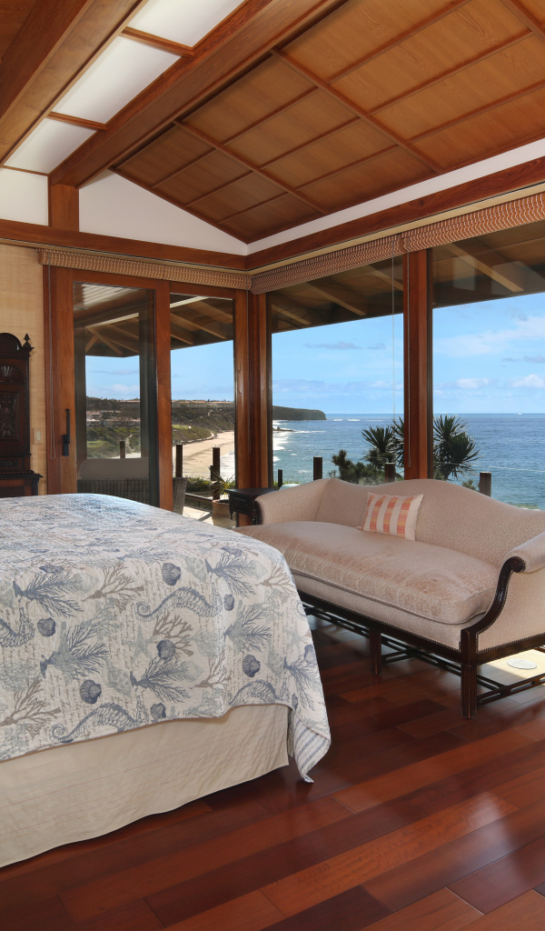 Wooden bedroom with a large bed and sea view