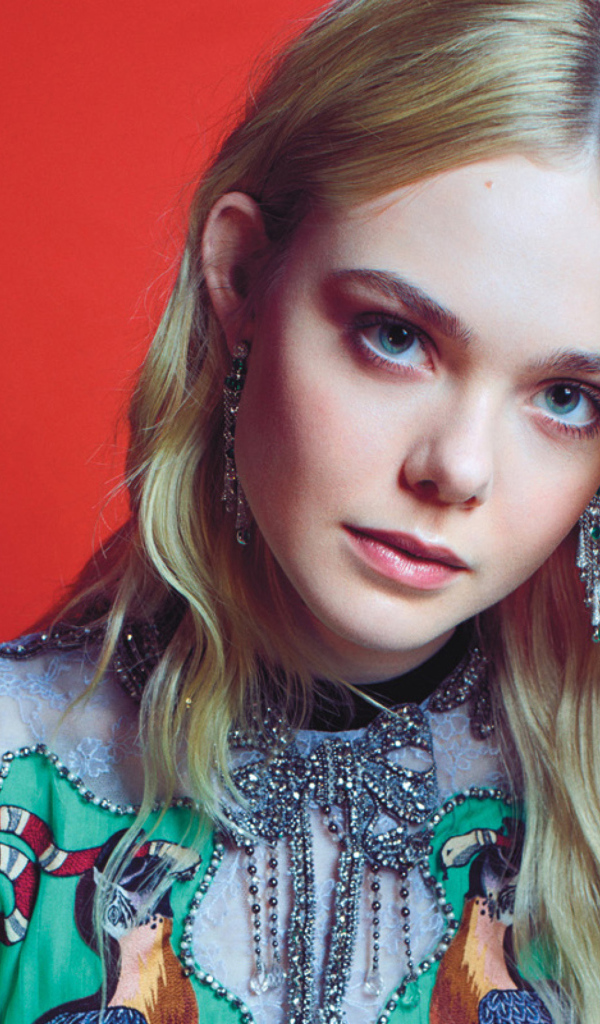 Молодая  блондинка, актриса Эль Фэннинг на красном фоне