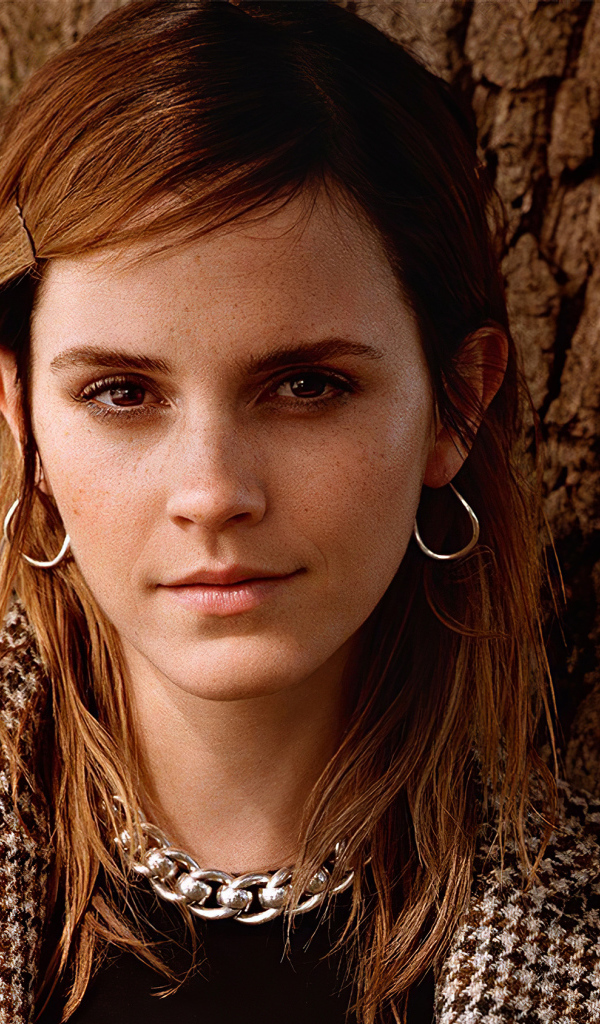 Молодая кареглазая девушка, актриса Эмма Уотсон у дерева