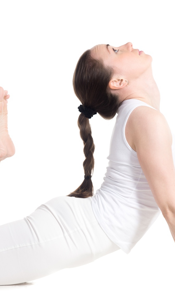 Молодая девушка делает растяжку на белом фоне