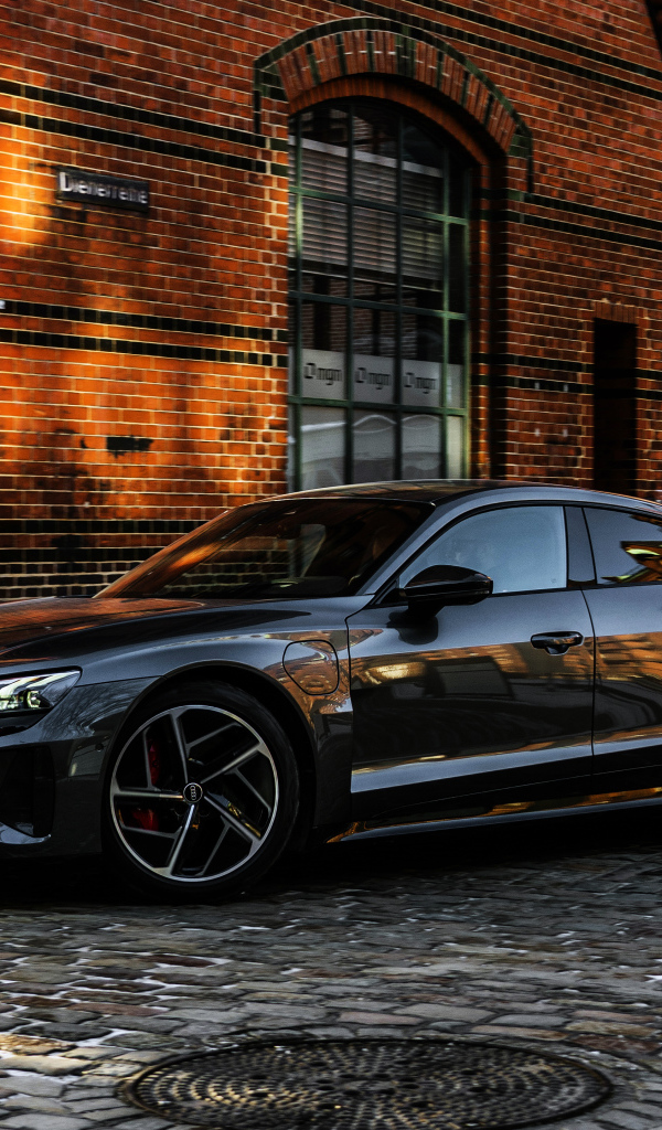 Черный автомобиль Audi RS E-Tron GT 2021 года у здания