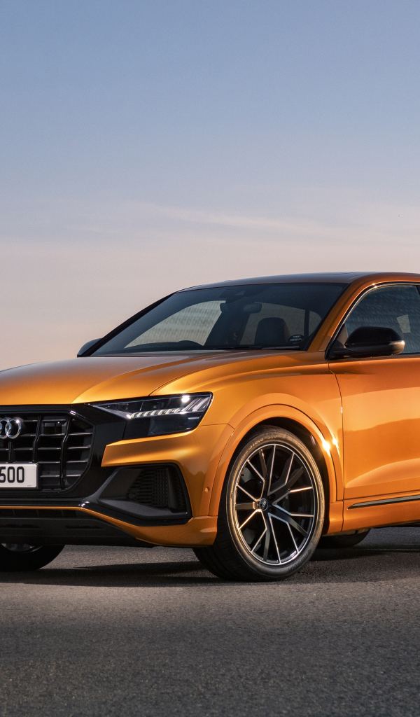 Оранжевый автомобиль Audi SQ8 TFSI 2021 года на фоне неба