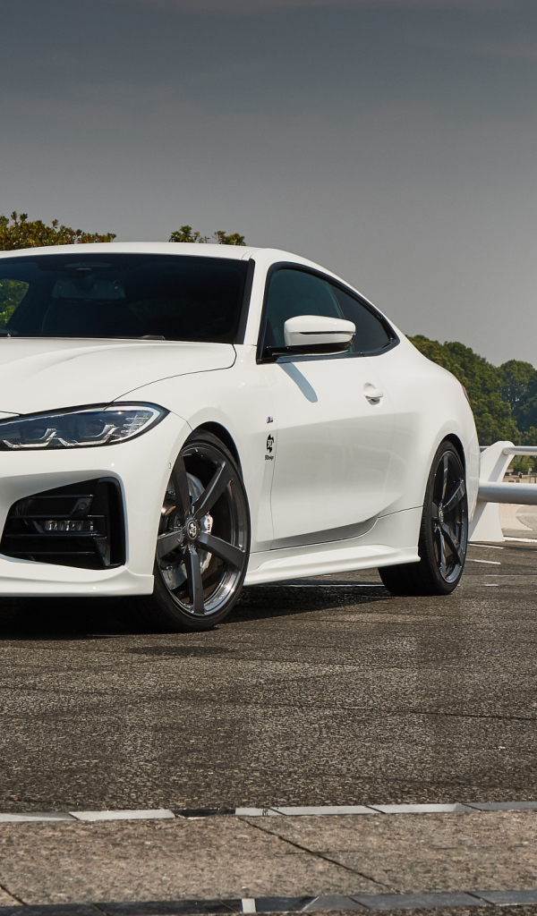 Белый автомобиль BMW 4 Series Coupé M Sport Package 2021 года у города