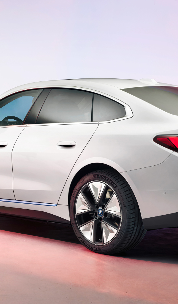 Белый автомобиль BMW I4 2021 года на розовом фоне