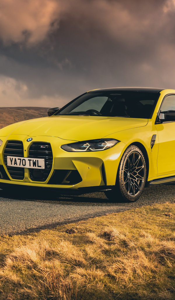 Желтый автомобиль BMW M4 Competition 2021 года на фоне грозового неба