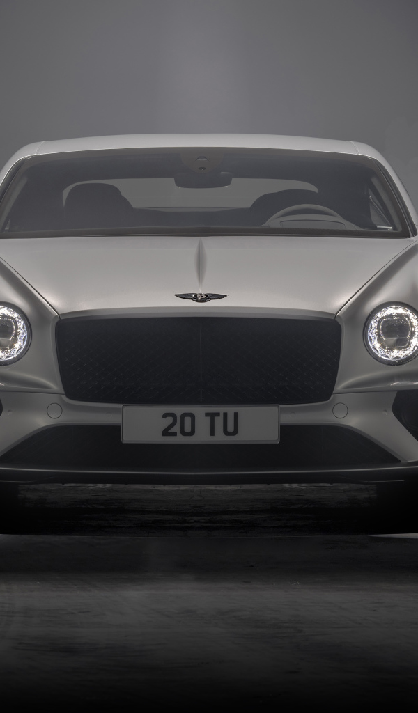 Серебристый автомобиль Bentley Continental GT Speed 2021 года на сером фоне
