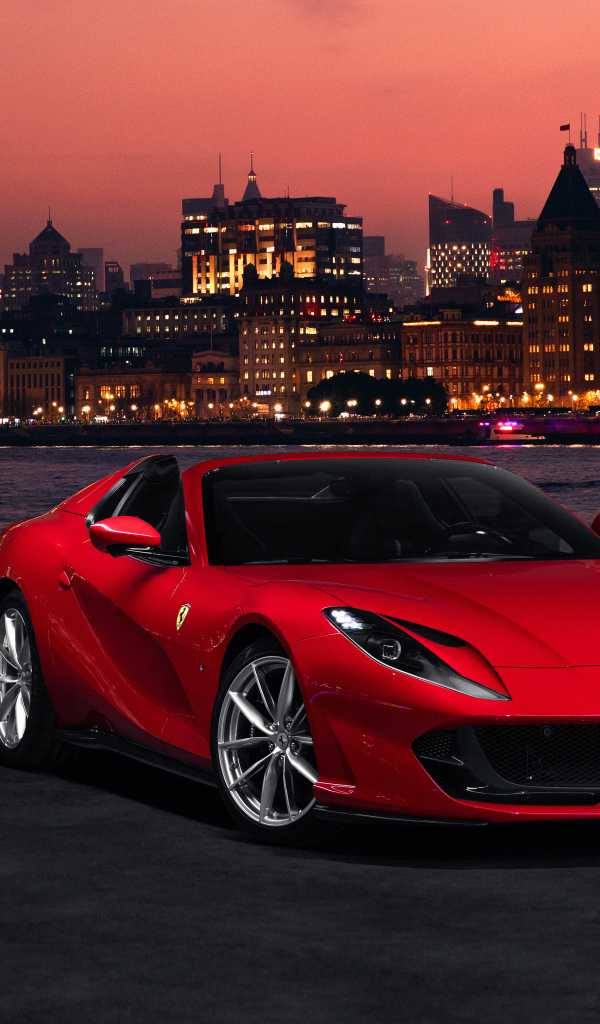 Красный автомобиль Ferrari 812 GTS  на фоне ночного города