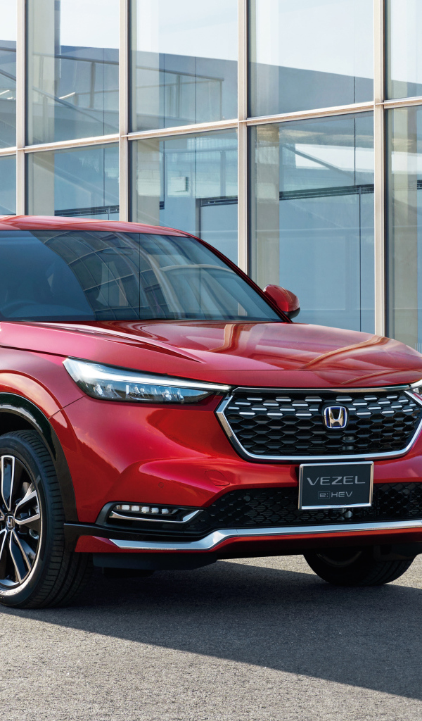 Красный автомобиль Honda Vezel EHEV 2021 у здания