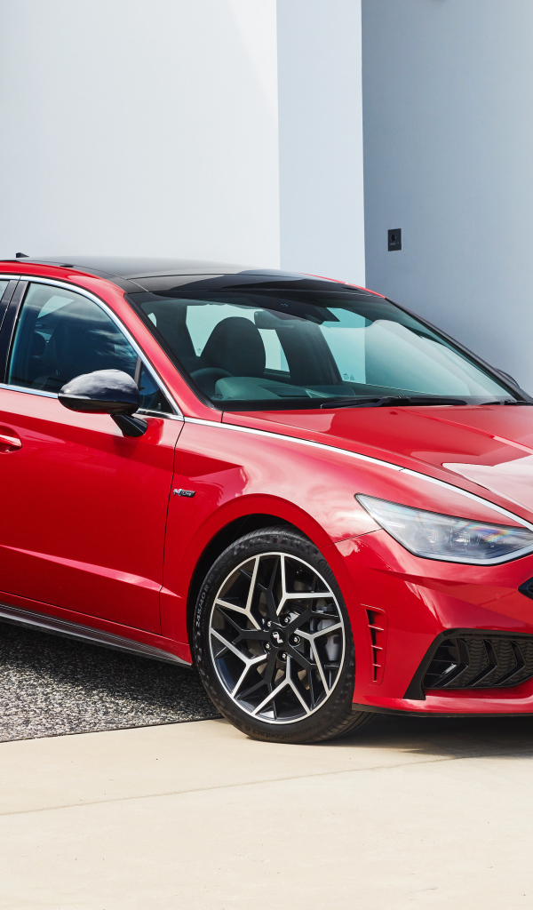 Красный автомобиль Hyundai Sonata N Line 2021 года у гаража