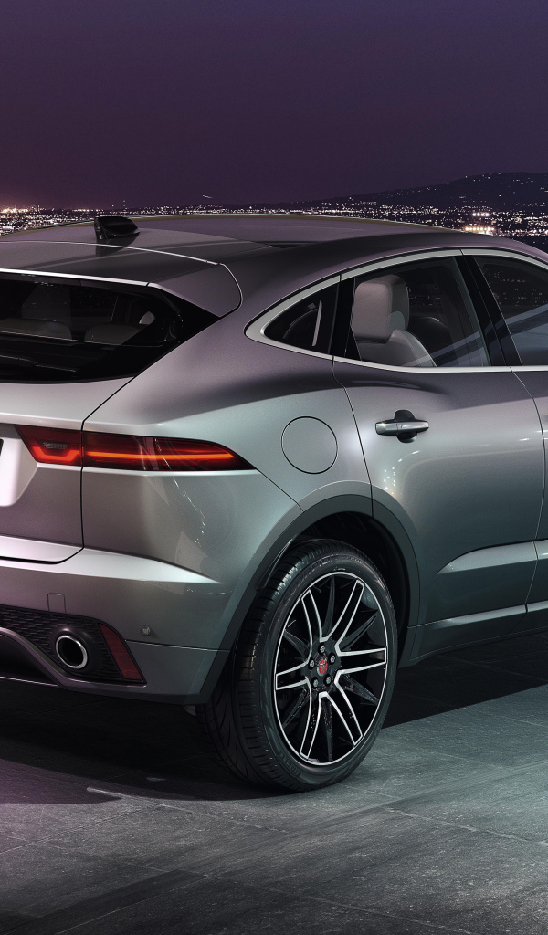 Серебристый Jaguar E-Pace R-Dynamic 2021 года на фоне ночного города