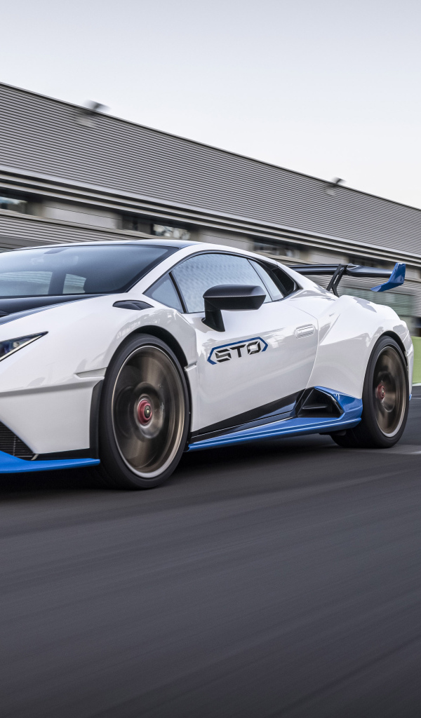 Белый автомобиль Lamborghini Huracán STO 2021 года на стадионе 