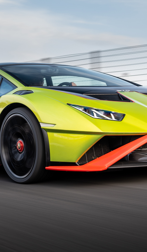 Зеленый автомобиль Lamborghini Huracán STO 2021 года на высокой скорости 