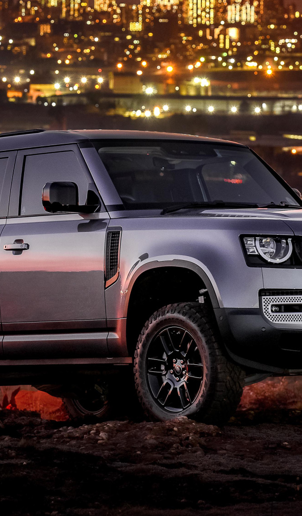 Серебристый внедорожник Land Rover Defender 110 P400 S Urban Pack 2021 года на фоне города