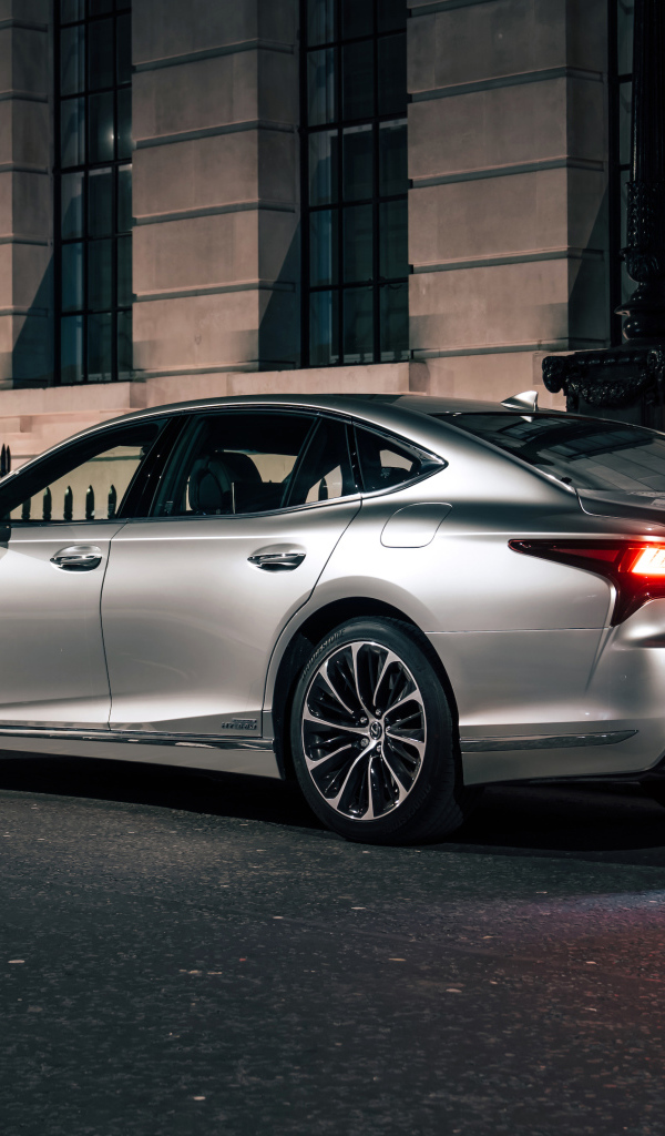 Серебристый автомобиль Lexus LS 500h 2021  года вид сзади