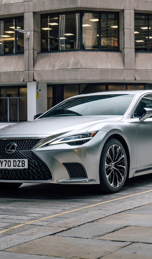 Серебристый автомобиль Lexus LS 500h 2021 года в городе у дома