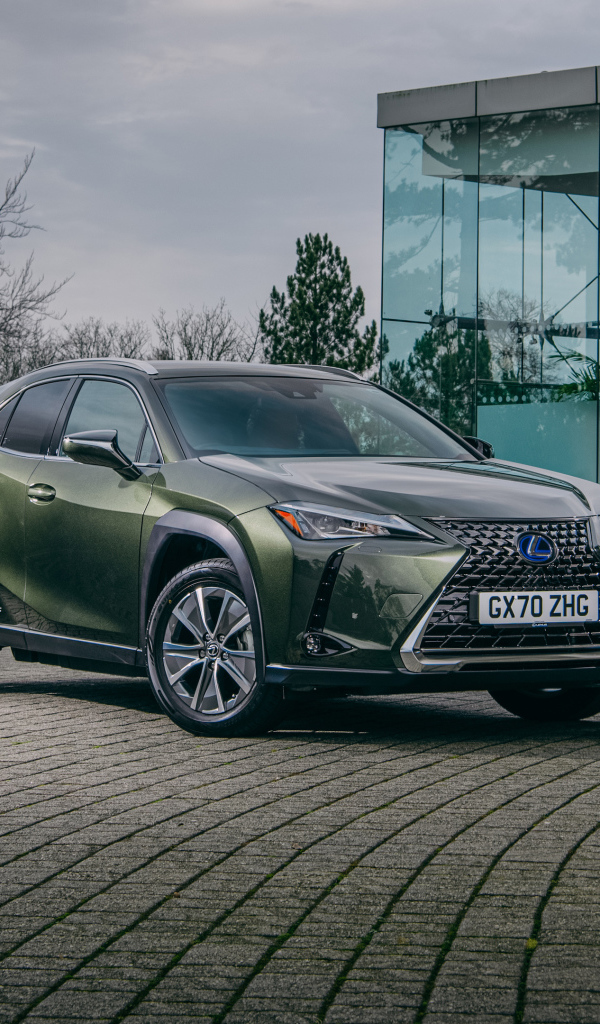 Зеленый автомобиль Lexus UX 300e 2021 года у стеклянной стены