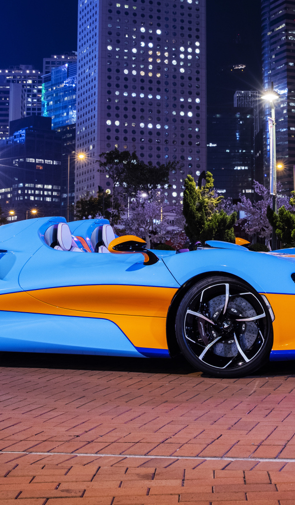 Автомобиль McLaren Elva Gulf Theme, 2021 года на фоне города