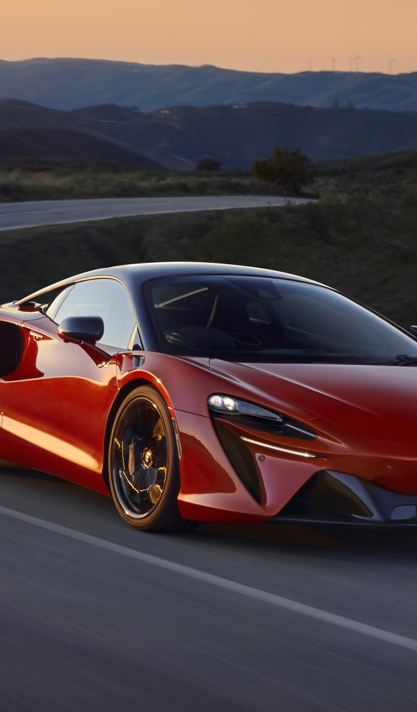 Красный автомобиль McLaren Artura, 2022 года на трассе