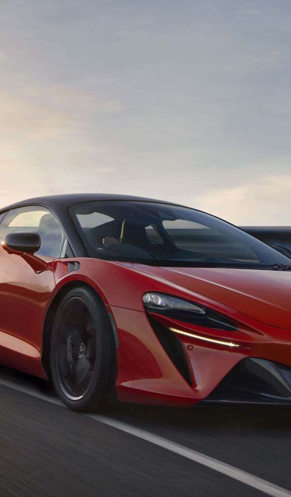 Красный быстрый автомобиль McLaren Artura, 2021 года на трассе