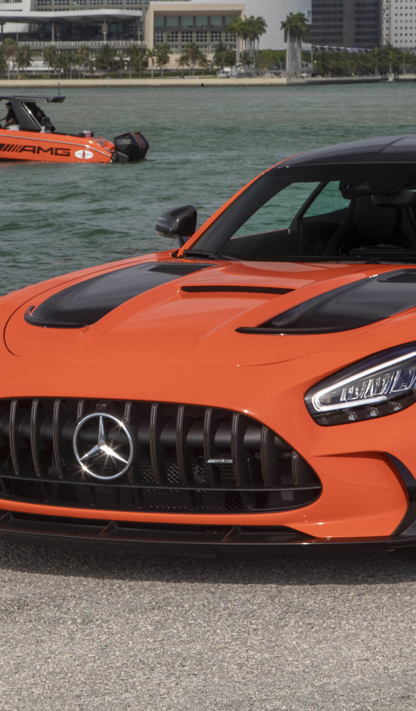 Оранжевый автомобиль Mercedes-AMG GT Black Series 2021 года у воды