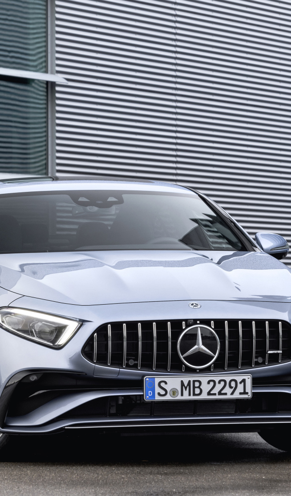 Серебристый автомобиль Mercedes-AMG CLS 53 4MATIC+ 2021 года у здания