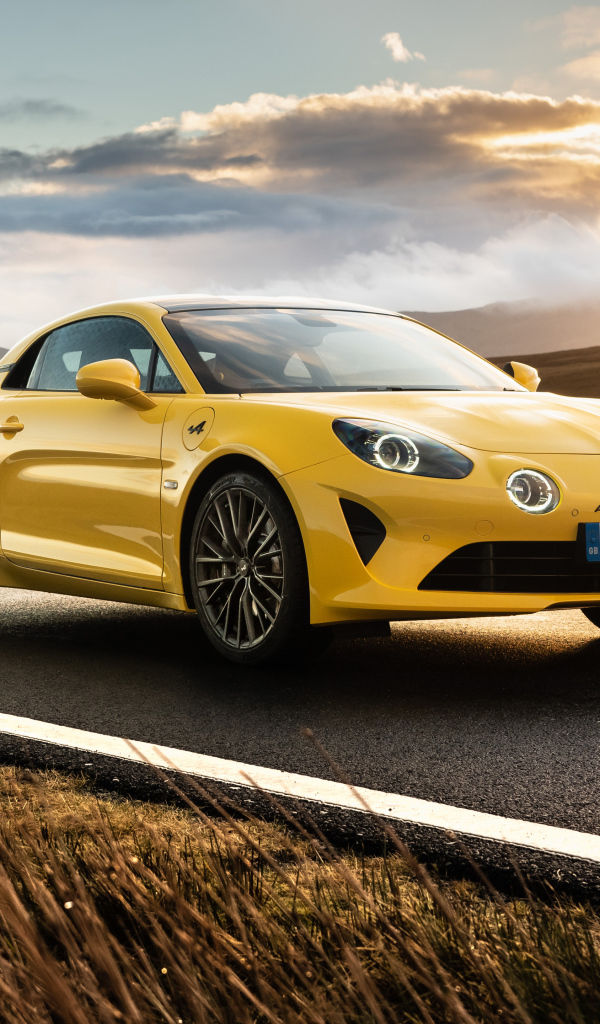 Желтый автомобиль Alpine A110, 2021 года на фоне заката