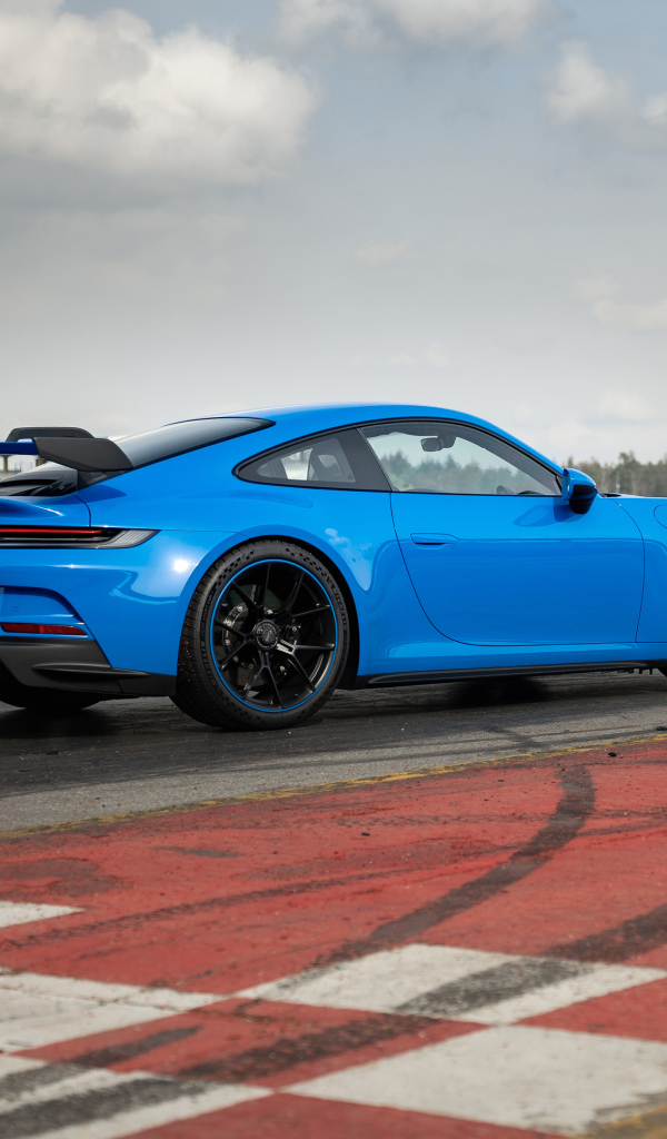 Голубой автомобиль  Porsche 911 GT3 2021 года на трассе