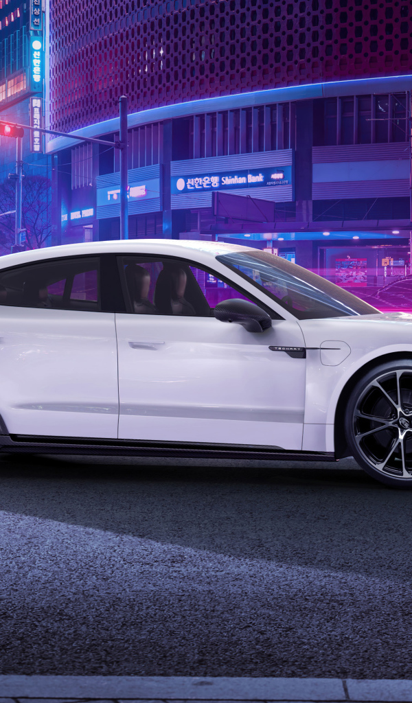 Белый автомобиль Porsche Taycan Aerokit 2021 года в мегаполисе