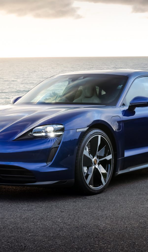 Синий автомобиль Porsche Taycan Turbo у моря
