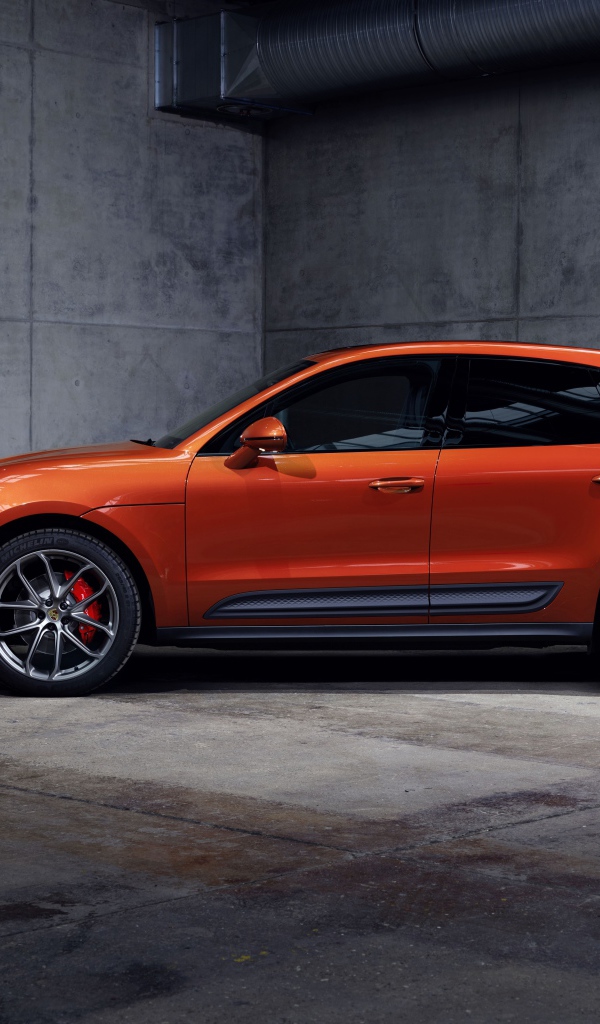 Оранжевый Porsche Macan S 2021  года на сером фоне