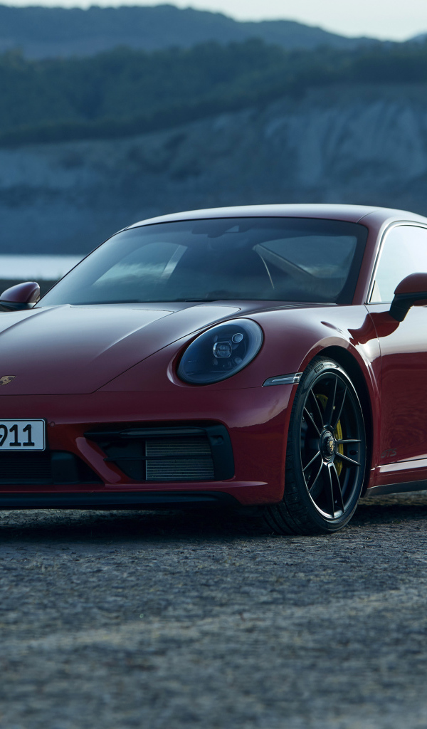 Красный Porsche 911 Carrera GTS 2021 года на фоне гор