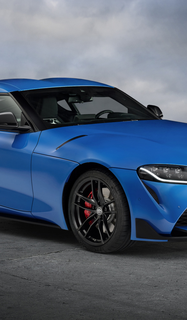 Синий автомобиль Toyota GR Supra, 2021 года на сером фоне