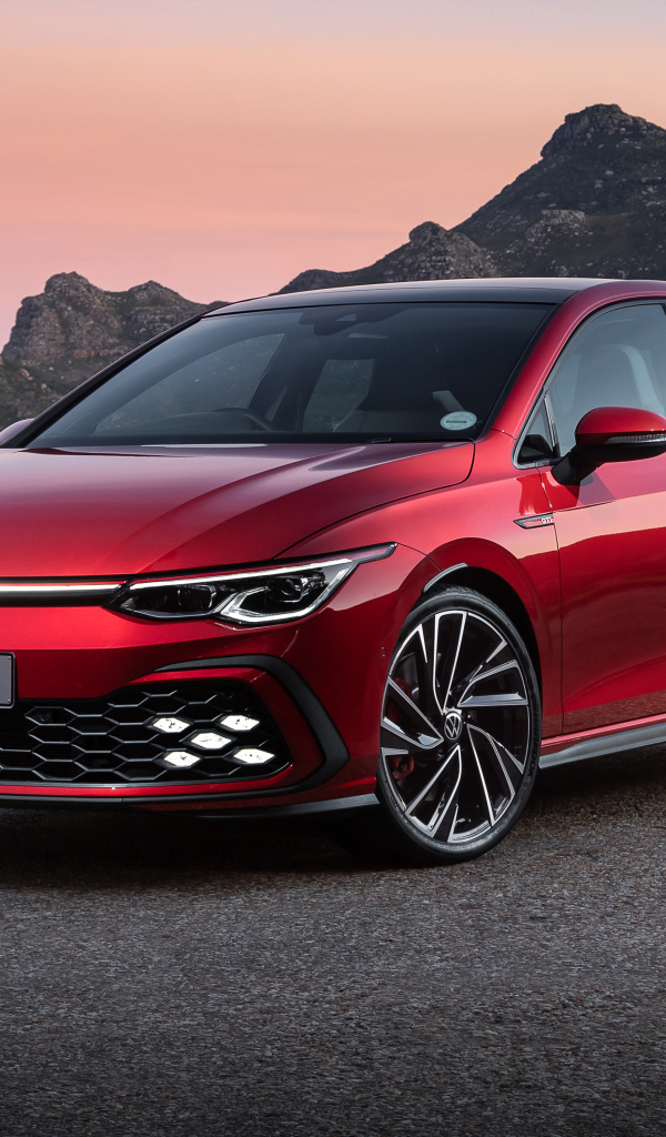 Красный Volkswagen Golf GTI 2021 года на фоне гор