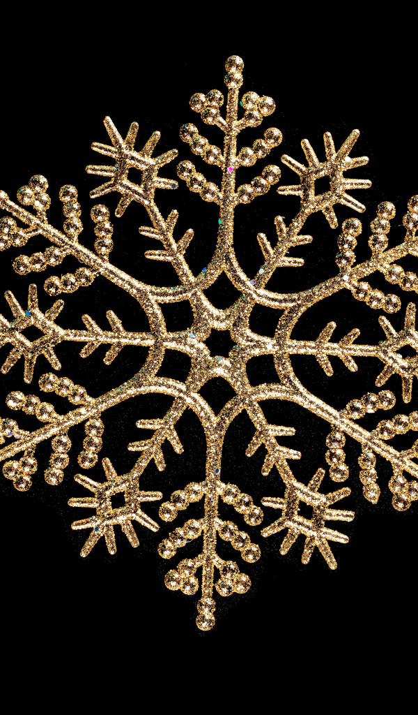 Красивая золотистая снежинка на черном фоне