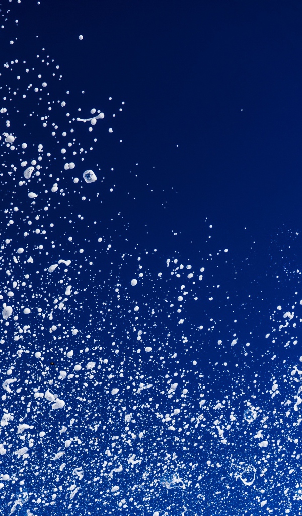 Белые брызги воды на синем фоне 