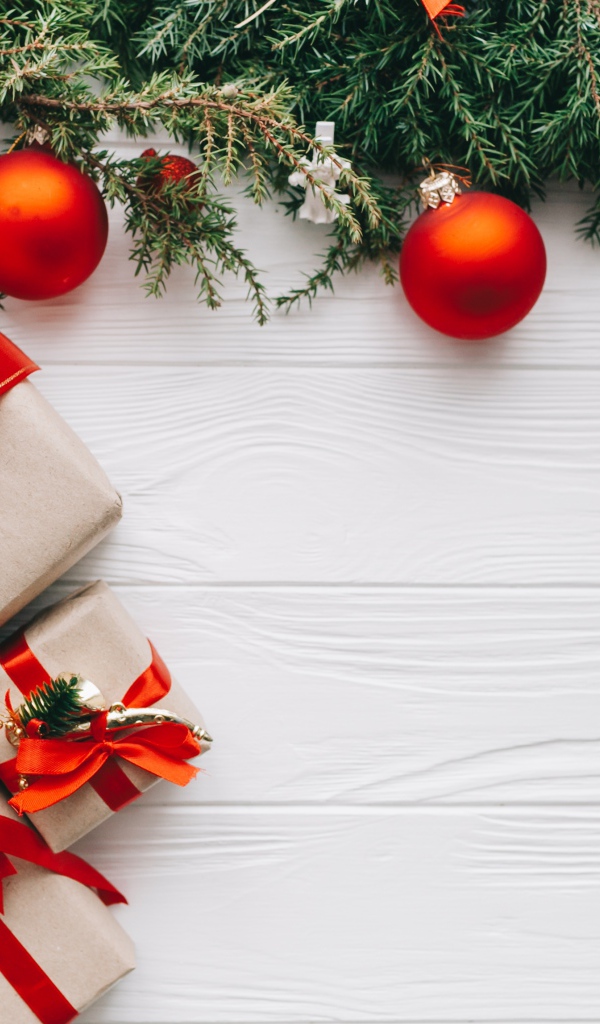 Подарки, еловая ветка и красные шары на Рождество 