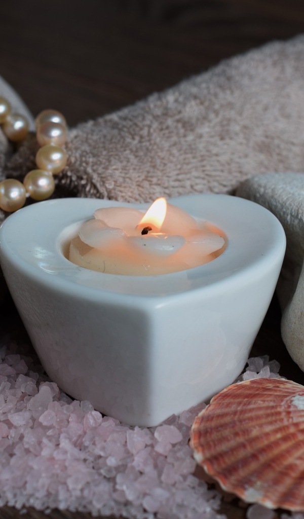 Красивая свеча с полотенцем, бусами, камнями и морской солью
