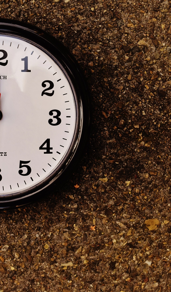 Большие черные часы висят на стене 