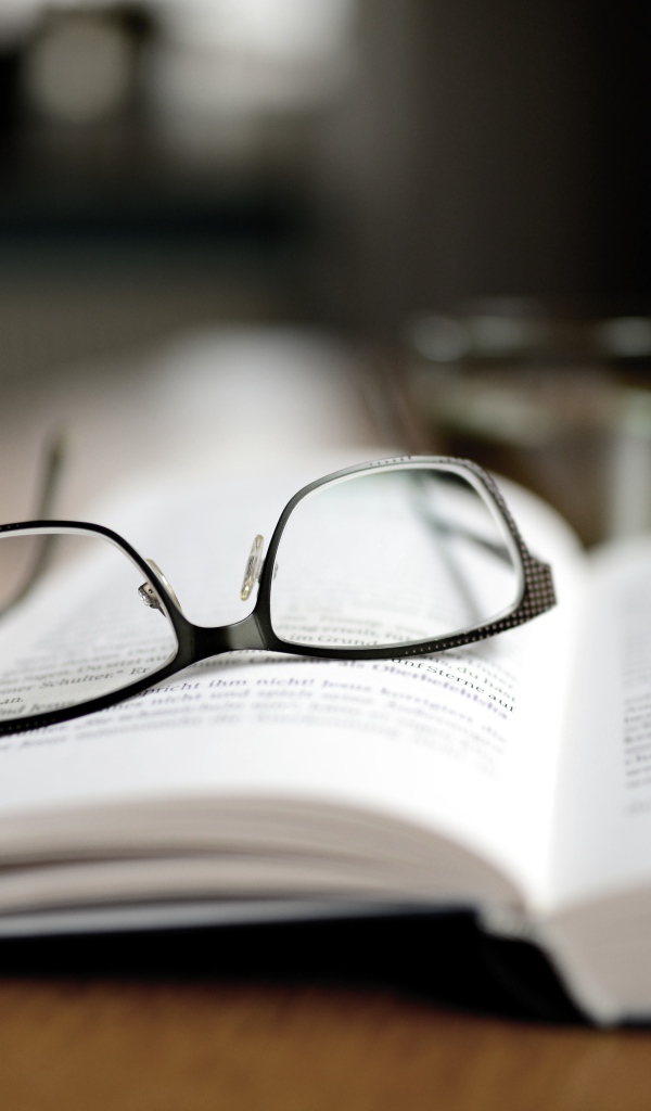 Черные очки лежат на книге 