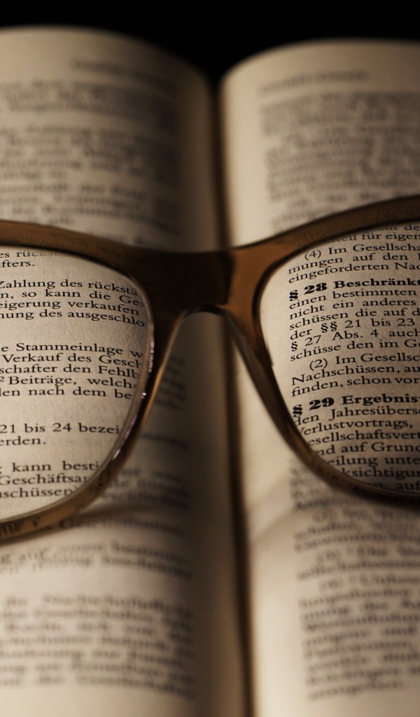 Очки для зрения лежат на открытой книге