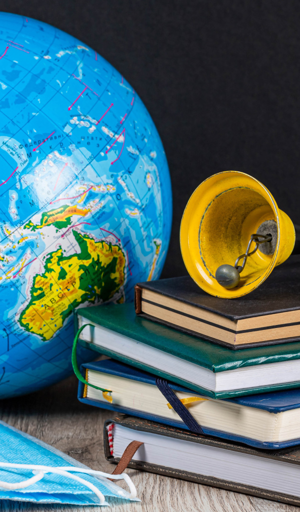 Глобус, книги, колокольчик и медицинские маски 