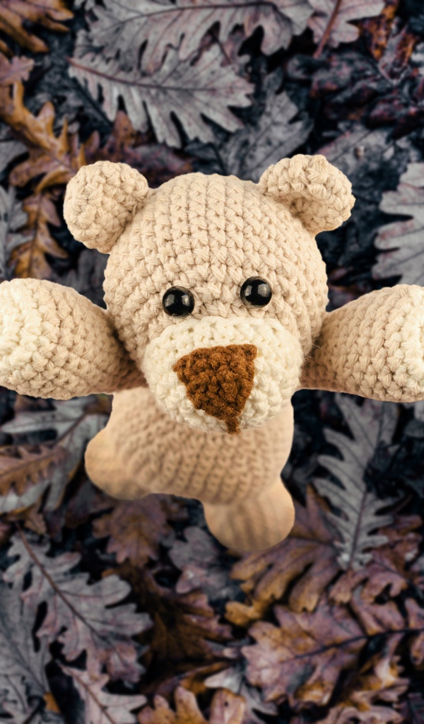 Вязаная игрушка медвежонок на листве